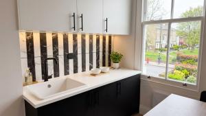a bathroom with a sink and a window at Clapton Station Luxury Studios near Central London in London