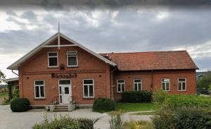a brick building with a sign on the front of it at Villa Bäckagård Bed and Breakfast in Åstorp