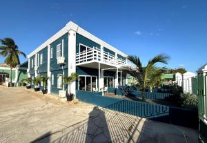 a blue building with palm trees in front of it at Villa Amalie & Villa Curiel in Willemstad