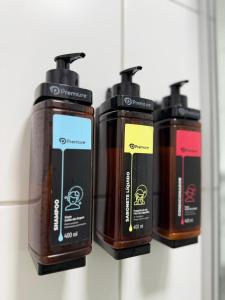 three bottles of soap sitting on a shelf at Prime BNB 1005 Experiência Premium in Petrolina +69 photos