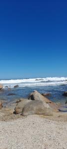 a group of rocks on a beach with the ocean at Cabañita en la Isla in Isla Negra +6 photos