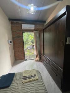 a room with a bed and a dresser and a window at Departamento en Lambare in Asunción