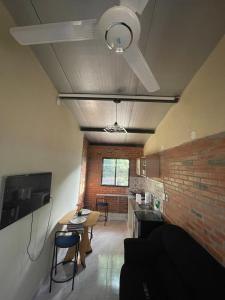 a living room with a ceiling fan and a brick wall at Departamento en Lambare in Asunción +4 photos