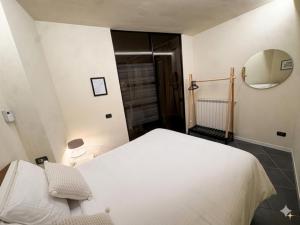 a bedroom with a white bed and a mirror at GB home in Azzano San Paolo