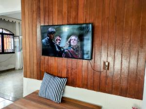 a flat screen tv on a wooden wall at Casa No Rio Garagem Wi-Fi Próximo Praia Barra in Rio de Janeiro