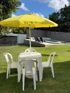 a table and two chairs under a yellow umbrella at Tres Soles 2 in Salsipuedes