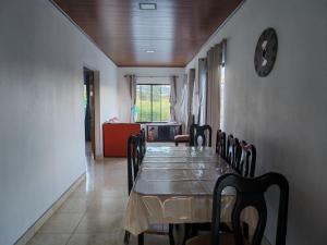 a dining room with a table and chairs and a clock at Vista Natural del Cerro in Grecia