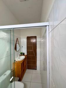 a bathroom with a sink and a toilet and a shower at Varanda das Dunas in Santo Amaro