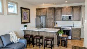 a kitchen with wooden cabinets and a kitchen island with bar stools at Henrys Fork Suites Suite One in Saint Anthony