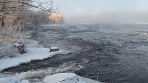 a river with snow on the sides of it at Henrys Fork Suites Suite One in Saint Anthony