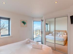 a bedroom with two beds and a balcony at 10 Horizons in Newquay