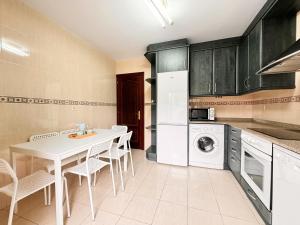 a kitchen with a white table and white appliances at Apartamentos Rurales LLeguera in Llanes