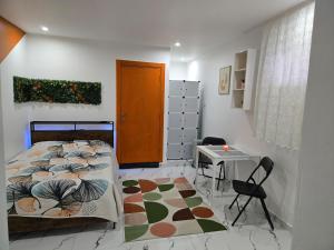 a bedroom with a bed and a table and a door at Cozy renovated studio Comfort practicality in Bourgoin +3 photos