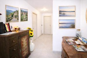 a room with a wooden dresser and paintings on the wall at BB Cadore casa vacanze in Varese