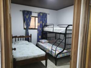 a room with two bunk beds and a bench at Vista Natural del Cerro in Grecia