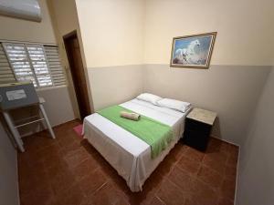 a bedroom with a bed and a painting on the wall at Ferrari's Hotell in Miguelópolis