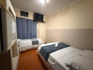 a hospital room with two beds and a window at Ferrari's Hotell in Miguelópolis