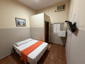 a bedroom with a bed and a television in it at Ferrari's Hotell in Miguelópolis