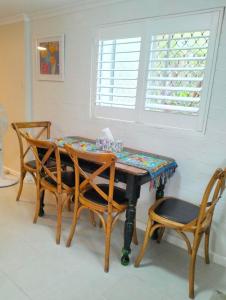 a dining room table with chairs and a window at Guest suite-2 beds,private entry, bathroom & laundry in Wollongong +10 photos