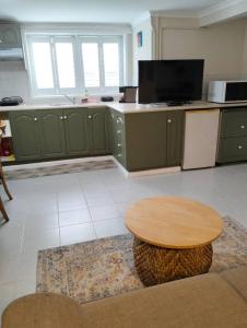 a kitchen with green cabinets and a wooden table at Guest suite-2 beds,private entry, bathroom & laundry in Wollongong