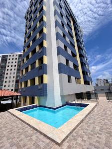a building with a swimming pool in front of a building at Refúgio em Intermares, 250m do Mar com piscina in Cabedelo