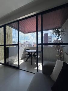 a living room with a table and a view of the city at Refúgio em Intermares, 250m do Mar com piscina in Cabedelo