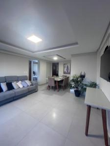 a living room with a couch and a table at Refúgio em Intermares, 250m do Mar com piscina in Cabedelo