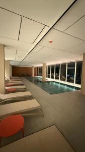 a swimming pool in a building withoccupied chairs at Almarena La Reserva UF 112 in Costa del Este