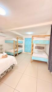 a bedroom with two bunk beds and a tiled floor at Pacific Blue in Monterrico