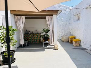 a patio with an umbrella and a table and chairs at Largo de Santa Ana in Cadaval