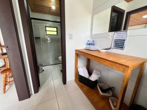 a bathroom with a wooden counter and a mirror at Pousada Jardim in Lauro Müller +37 photos