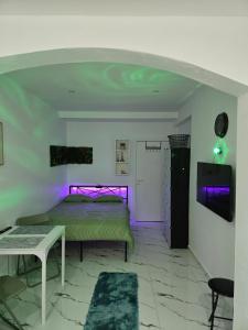 a bedroom with a bed with purple lights on it at Studio modern climatise in Bourgoin