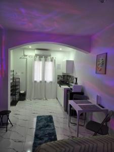 a living room with a purple ceiling and a table at Studio modern climatise in Bourgoin
