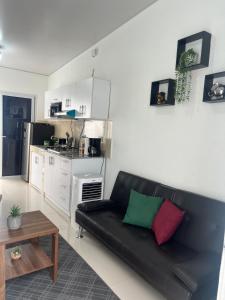 a living room with a black couch and a kitchen at Casa Migueleña in San Miguel