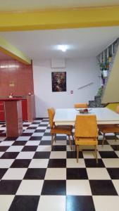 a room with a table and chairs on a checkered floor at El Pedregullo in Neuquén