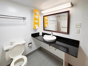 a bathroom with a toilet and a sink and a mirror at Motel 6-New Stanton, PA in New Stanton +34 photos