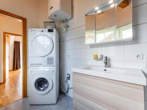 a bathroom with a washing machine and a sink at Gailblick in Kötschach +31 photos