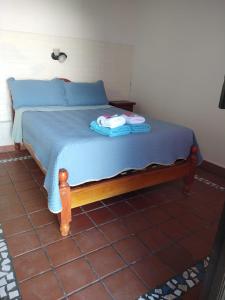a bed with blue sheets and two towels on it at Camino del Inca in Cachí