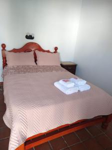 a bedroom with a bed with two towels on it at Camino del Inca in Cachí