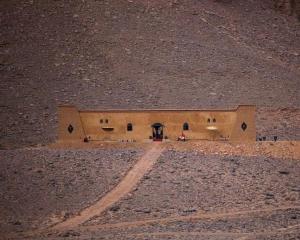 a building in the middle of a desert at night at Riad Nomad in Foum Mharech