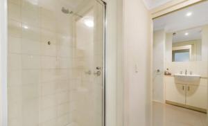 a white bathroom with a shower and a sink at Ground level unit with private courtyard in Melton