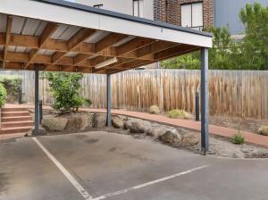 a covered parking lot in front of a fence at Ground level unit with private courtyard in Melton