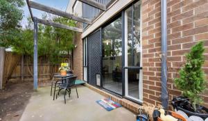 a patio with a table and chairs next to a brick building at Ground level unit with private courtyard in Melton