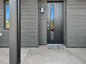 a blue door on a gray building with a sidewalk at Terrace at Two Rivers townhouse in Grand Junction
