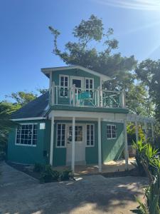 a house with a balcony on top of it at Bak A Yaad in Negril