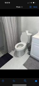 a bathroom with a toilet and a shower curtain at Bedroom with Bathroom 1 in Boca Raton +2 photos