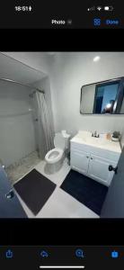 a bathroom with a toilet and a sink and a mirror at Bedroom with Bathroom 1 in Boca Raton