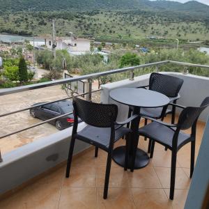 a balcony with two chairs and a table and a view at Villa LeoZeka in Ksamil