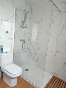 a white bathroom with a shower and a toilet at Sea Bay House in Lagoa