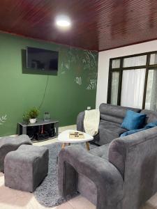 a living room with two couches and a tv at Hostal Amelia Filandia in Filandia